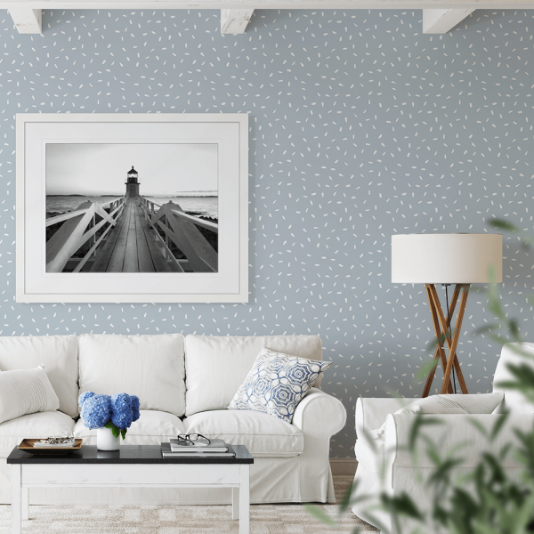 Black and white wall art features a single pier cascading into the deep ocean, culminating at a light house, wall mounted in a white frame