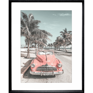 Black framed Wanderlust Wall Art - Havana 02 - Studio Collection, featuring a pink dodge car travelling down the Palm coastline.