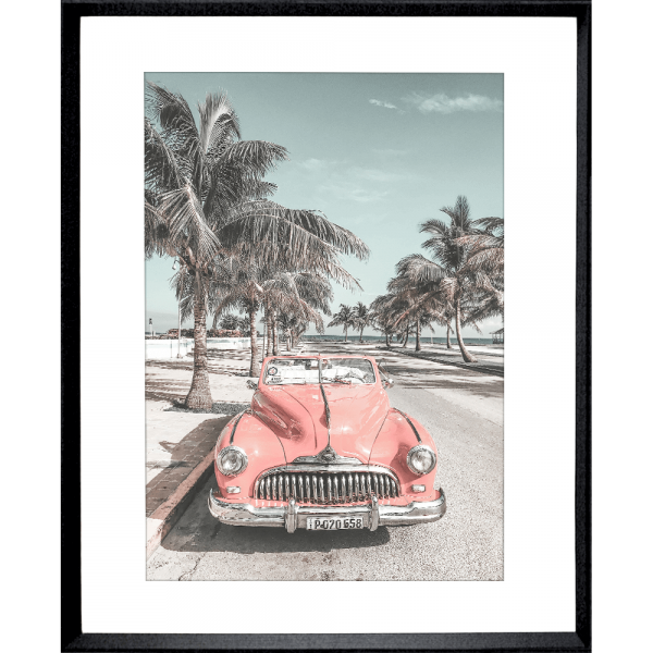 Black framed Wanderlust Wall Art - Havana 02 - Studio Collection, featuring a pink dodge car travelling down the Palm coastline.