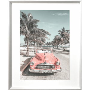 Silver framed Wanderlust Wall Art - Havana 02 - Studio Collection, featuring a pink dodge car travelling down the Palm coastline.