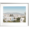 Coastal Wall Art featuring white coastal buildings against a backdrop of similar white building, rolling hills and blue skyline in white frame