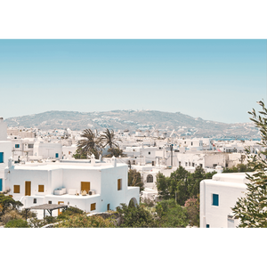 Coastal Wall Art featuring white coastal buildings against a backdrop of similar white building, rolling hills and blue skyline on canvas