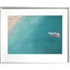 Silver framed Coastal Wall Art featuring a dark to light aqua ocean and a single white boat drifting towards the shoreline.