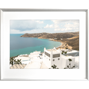 Silver framed Modern coastal wall art featuring  crisp white buildings against a backdrop of the crystal blue ocean