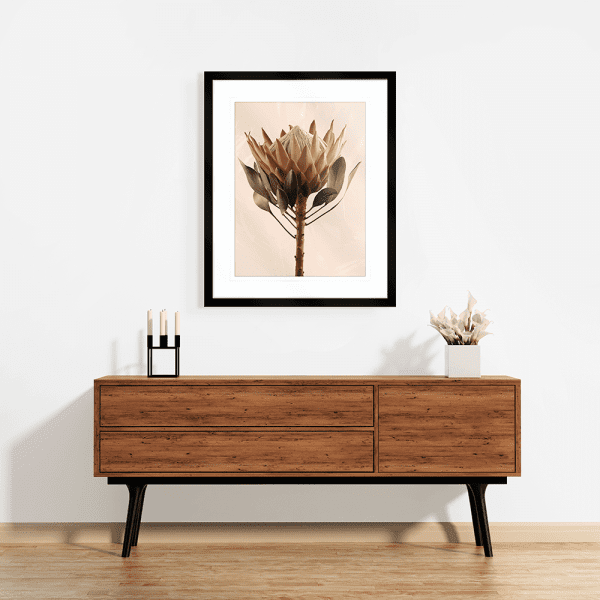 Mounted black framed Australian Native Flower Wall Art, Featuring a single blooming Australian flower in soft pinks and green tones, again a dusty pink background