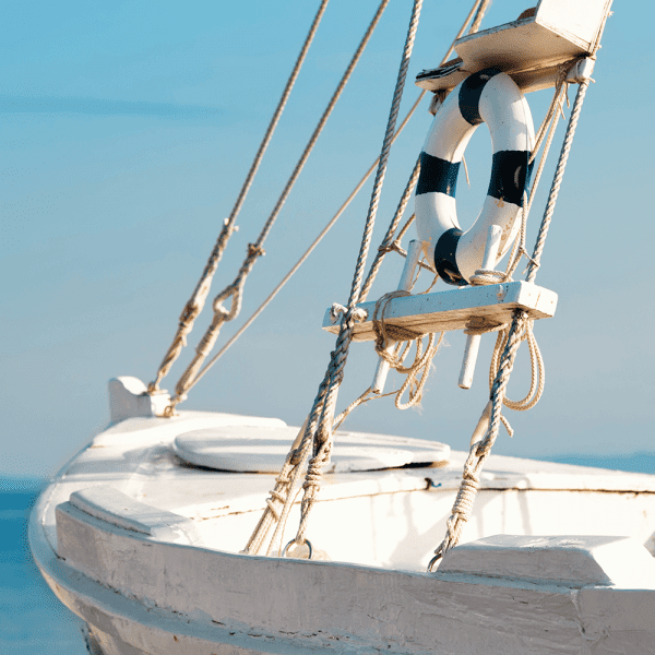 Unframed Nautical Wall Art Canvas, featuring a single crisp white sailing ship floating on a pristine sky-blue ocean, against a pale blue skyline