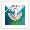 White Framed Nautical Wall Art, featuring the front section of white and light blue sailing ship floating on a pristine green ocean, moored with white nautical ropes.