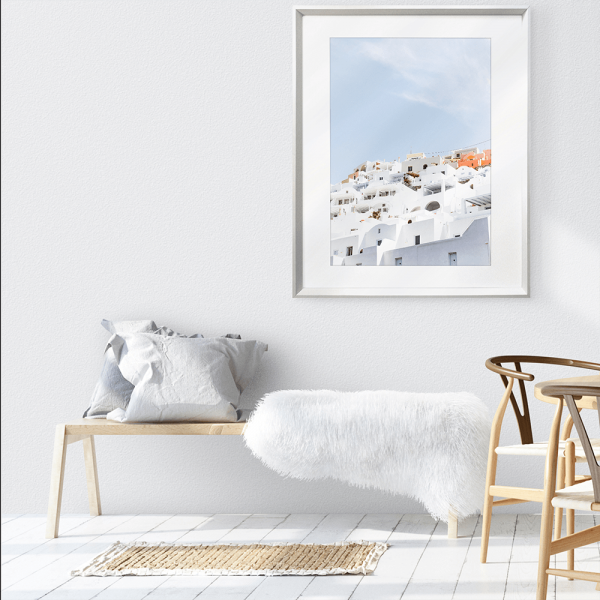 Wall mounted Greek Island Photo featuring iconic European white coastal homes under a soothing pale blue skyline.