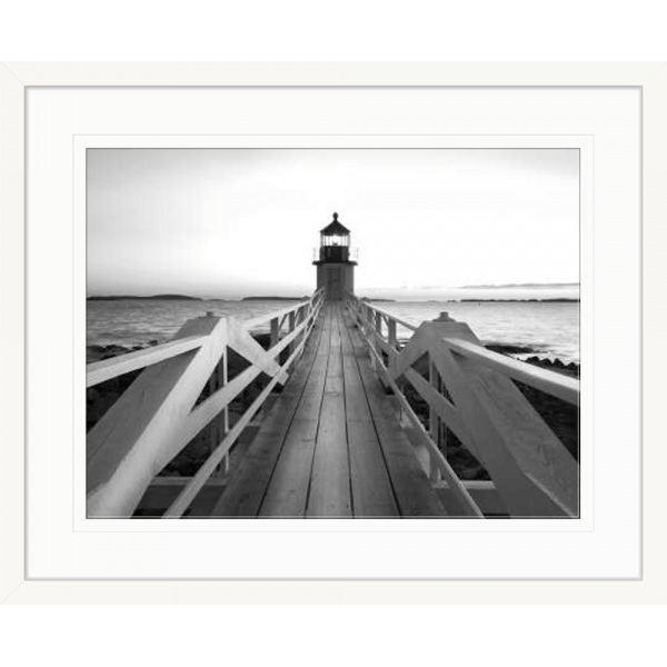 Black and white wall art features a single pier cascading into the deep ocean, culminating at a light house in a white frame