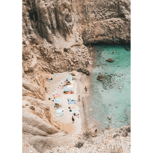 Unframed Coastal Wall Art - Vacanza 01 – Studio Collection, Featuring a relaxing beach scene nestled within a cliff face. Clear aqua water with beach lovers sun baking in the sunshine.