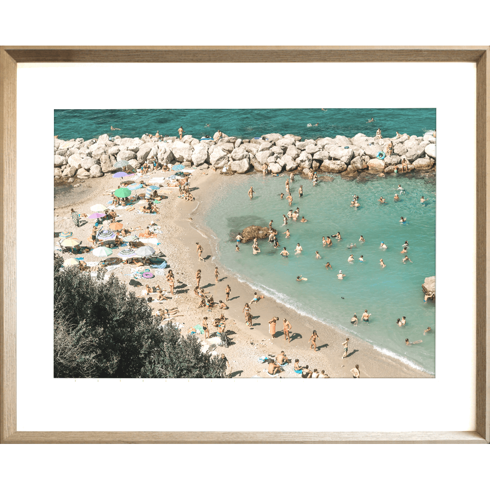 Gold framed Coastal Wall Art Vacanza 02 – Studio Collection, featuring the European beach coastline with holiday beach lovers bathing in the sunshine.