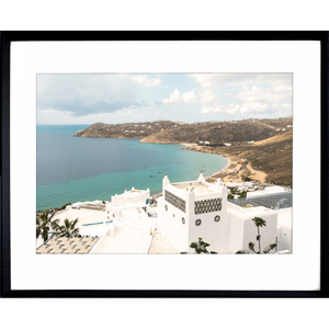 Black framed Modern coastal wall art featuring  crisp white buildings against a backdrop of the crystal blue ocean