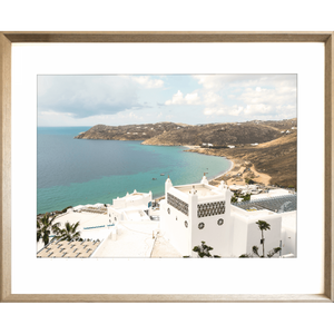 Gold framed Modern coastal wall art featuring  crisp white buildings against a backdrop of the crystal blue ocean